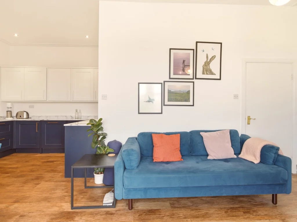 Blue sofa adds colour to the open-plan living and kitchen space.