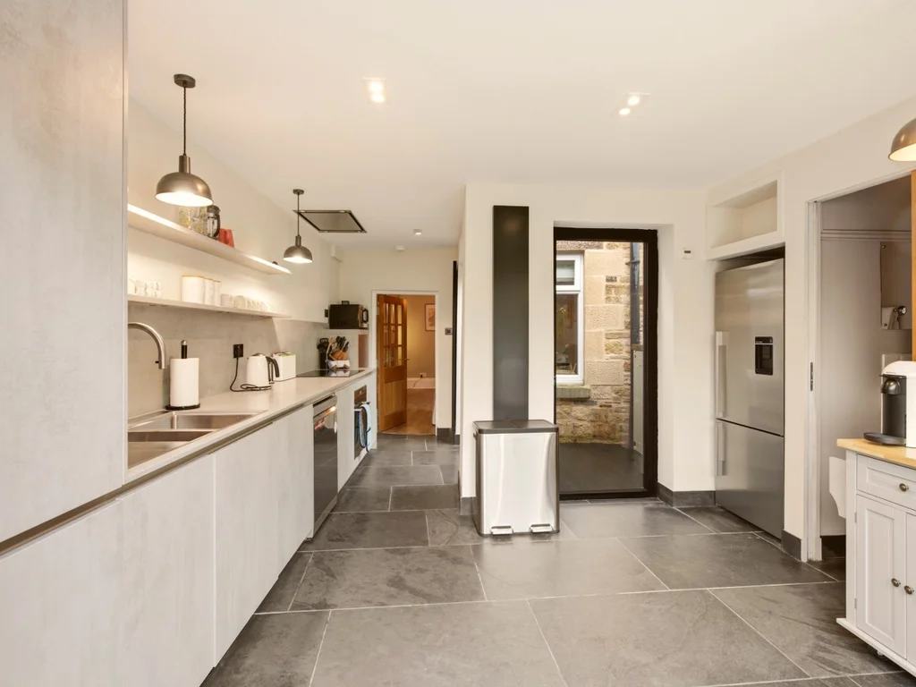 Spacious modern kitchen with extensive worktops and integrated appliances.