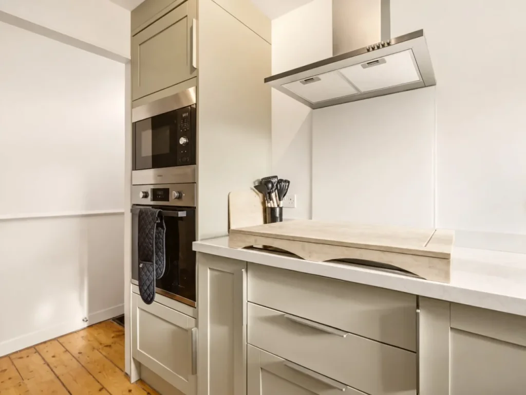 Fitted kitchen with integrated oven, microwave, hob and extractor hood