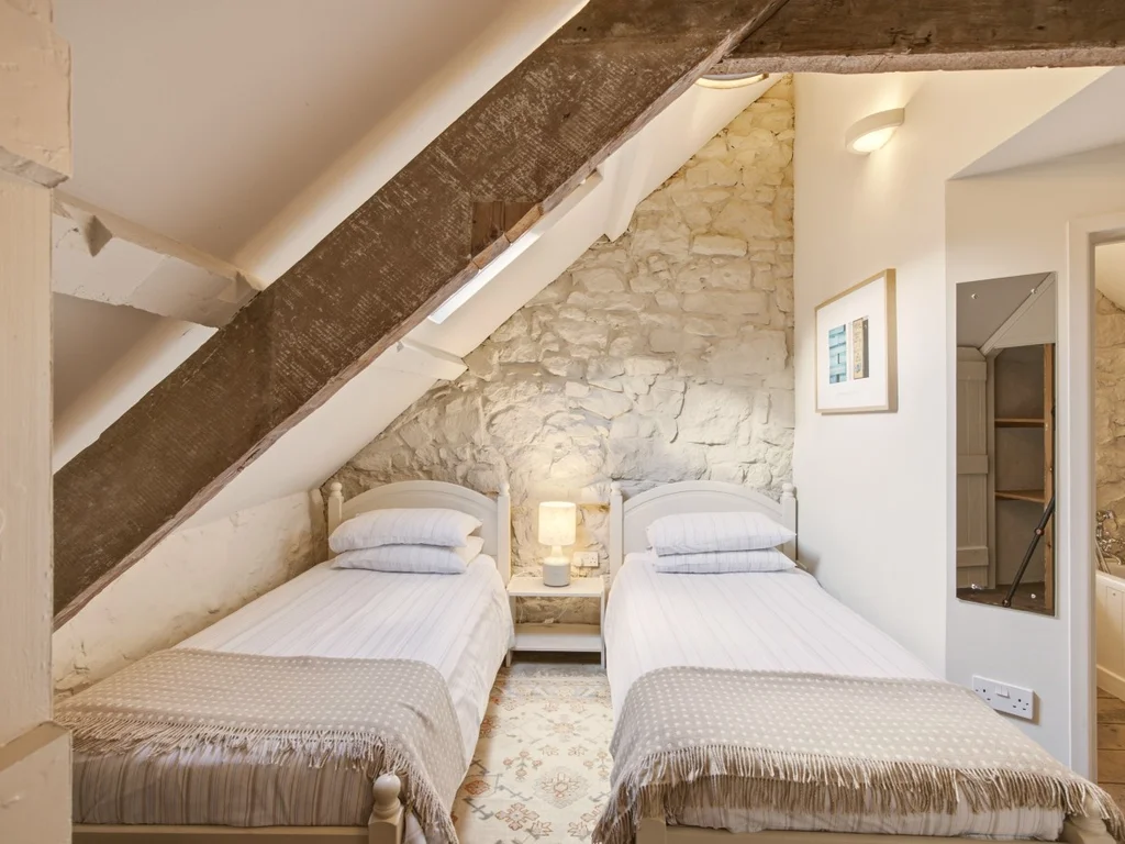 Twin bedroom tucked beneath the cottage's original wooden beams