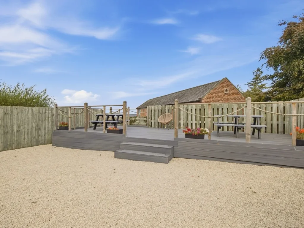 Enclosed decked area with outdoor seating overlooking the shared grounds