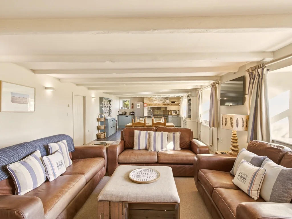 Spacious sitting room with leather sofas and a central coffee table