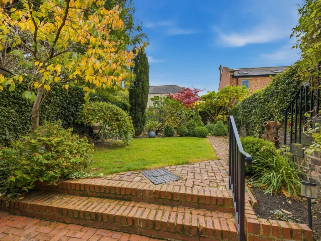 Enjoy the private garden with its brick patio and mature greenery