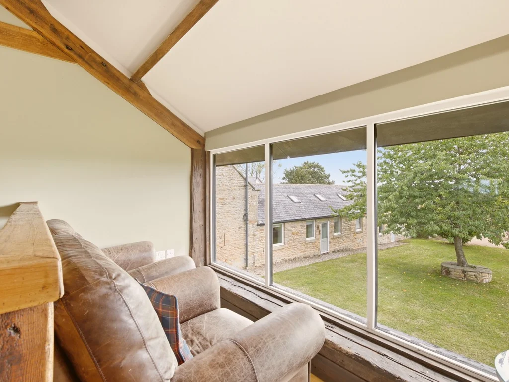 Upper seating area with large window overlooking the shared grounds