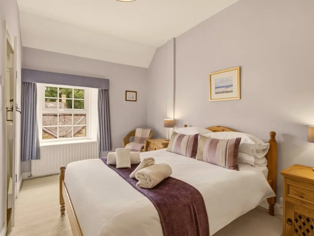 Bright double bedroom with garden views and warm oak bedroom furnishings