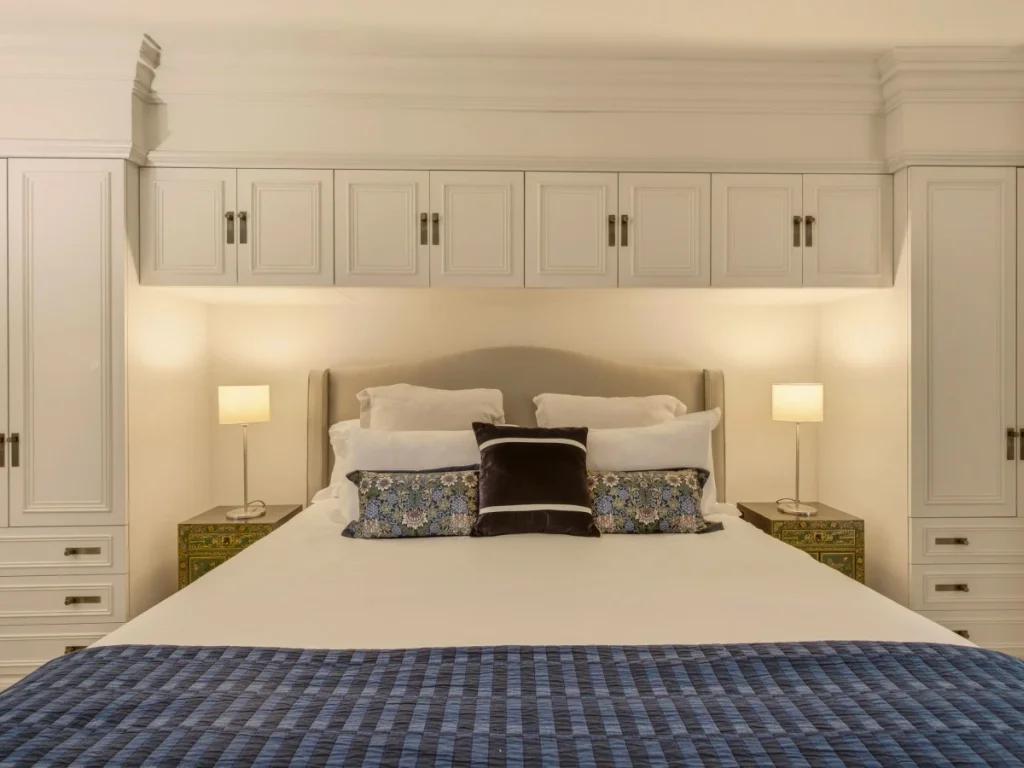 Super king bed with fitted cabinetry and bedside lighting