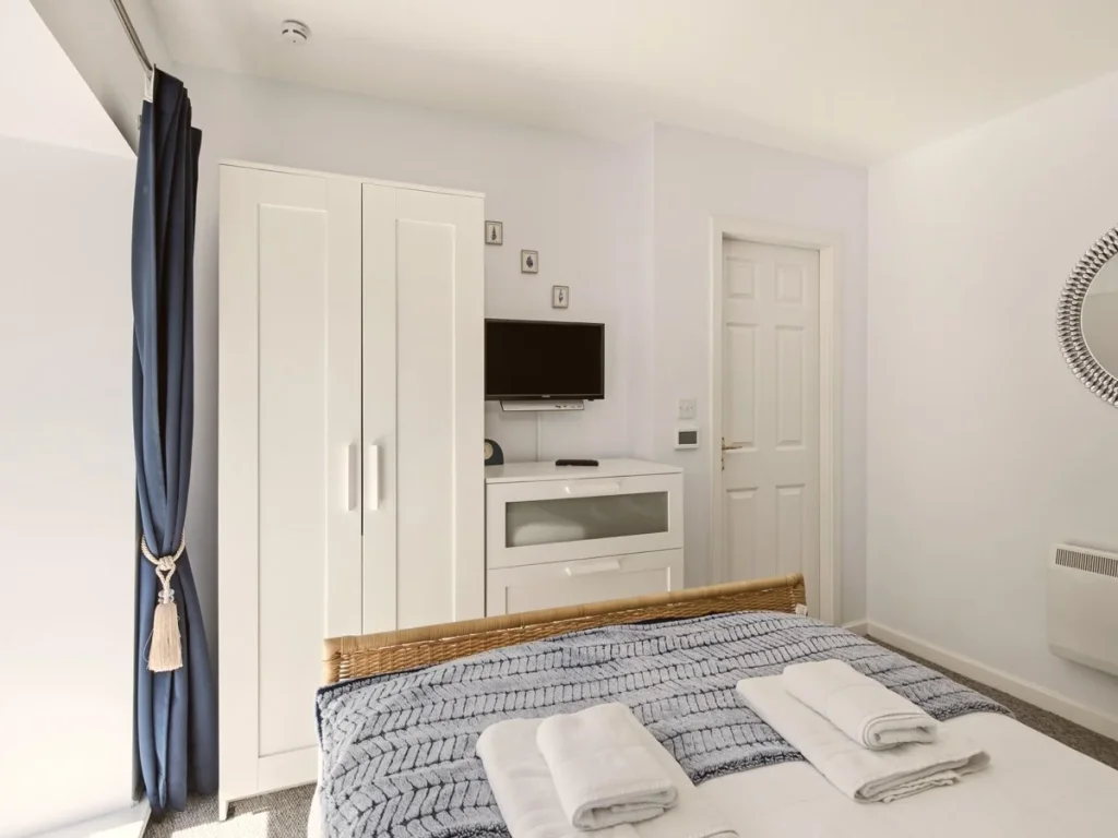 Master bedroom with wardrobe, Smart TV, mirror and ample storage space