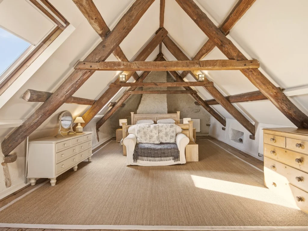 Main bedroom suite with a super king bed and exposed timber beams