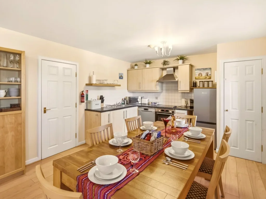 Dining area set for six beside the well-equipped open-plan kitchen