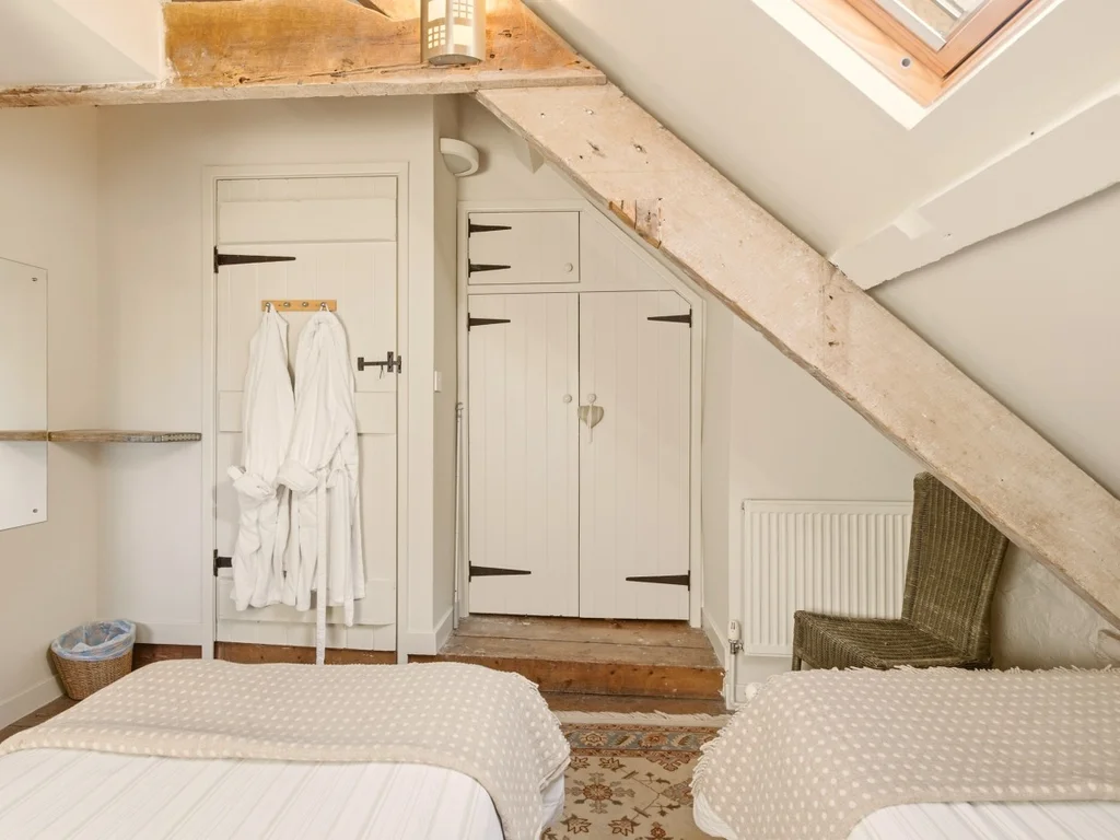 Cosy twin room with wooden beams and a stone feature wall