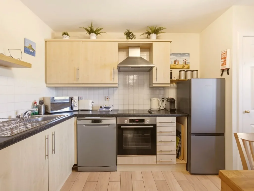 Well-equipped kitchen with oven, dishwasher, fridge freezer and storage