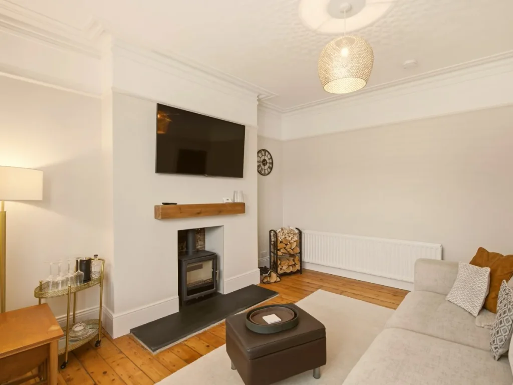 Living room with log burner, wall-mounted Smart TV and stacked logs