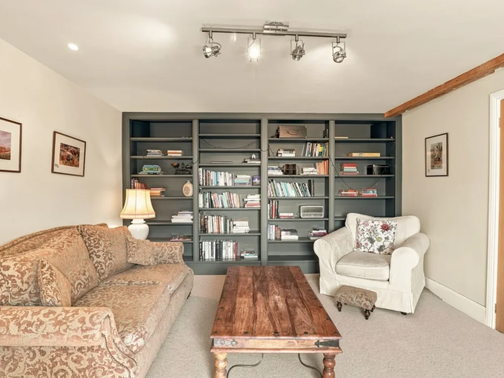 Living room with full bookshelves, patterned sofa and armchair
