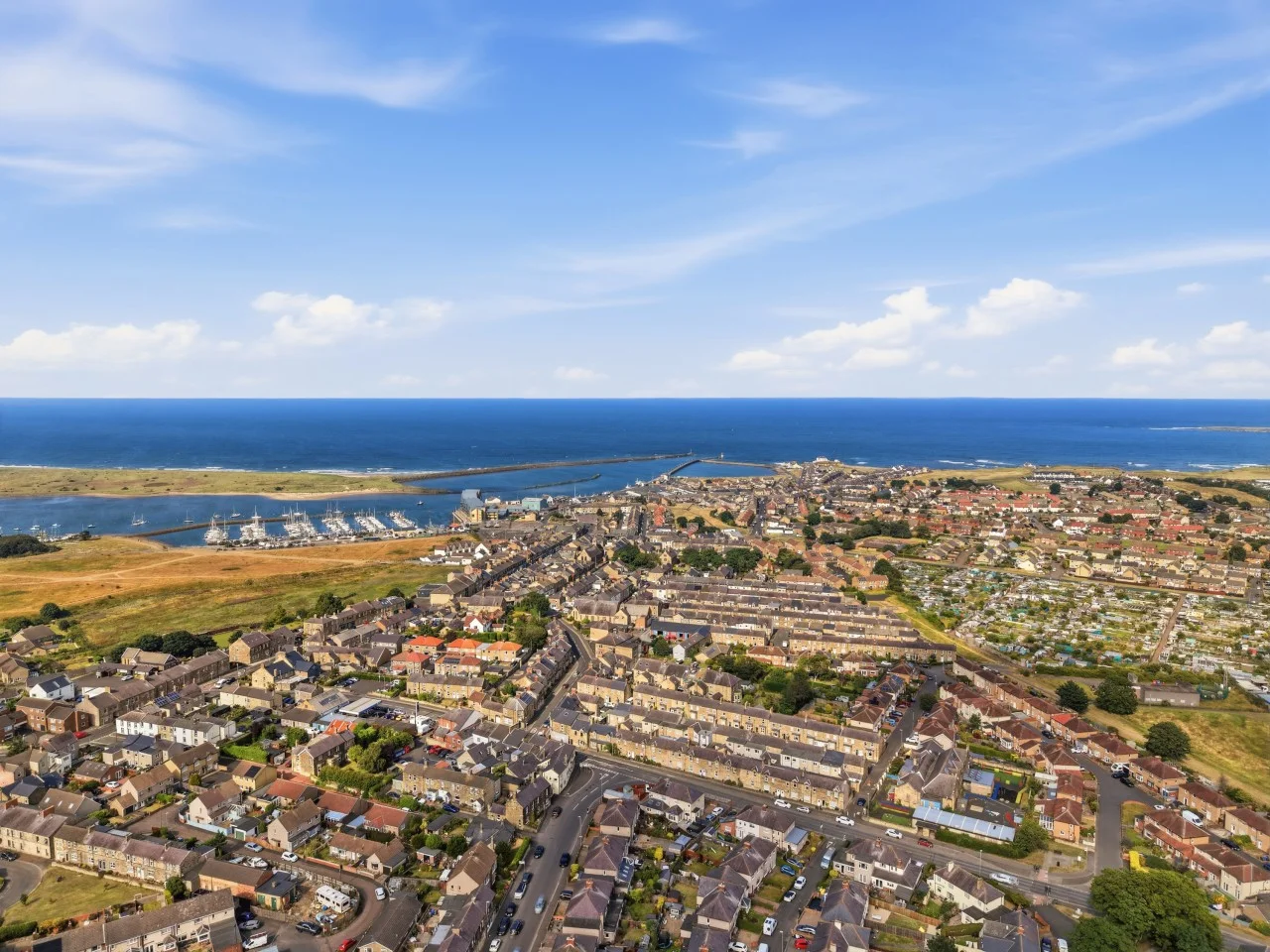 Aerial view of Amble harbour, marina and Northumberland coastline.