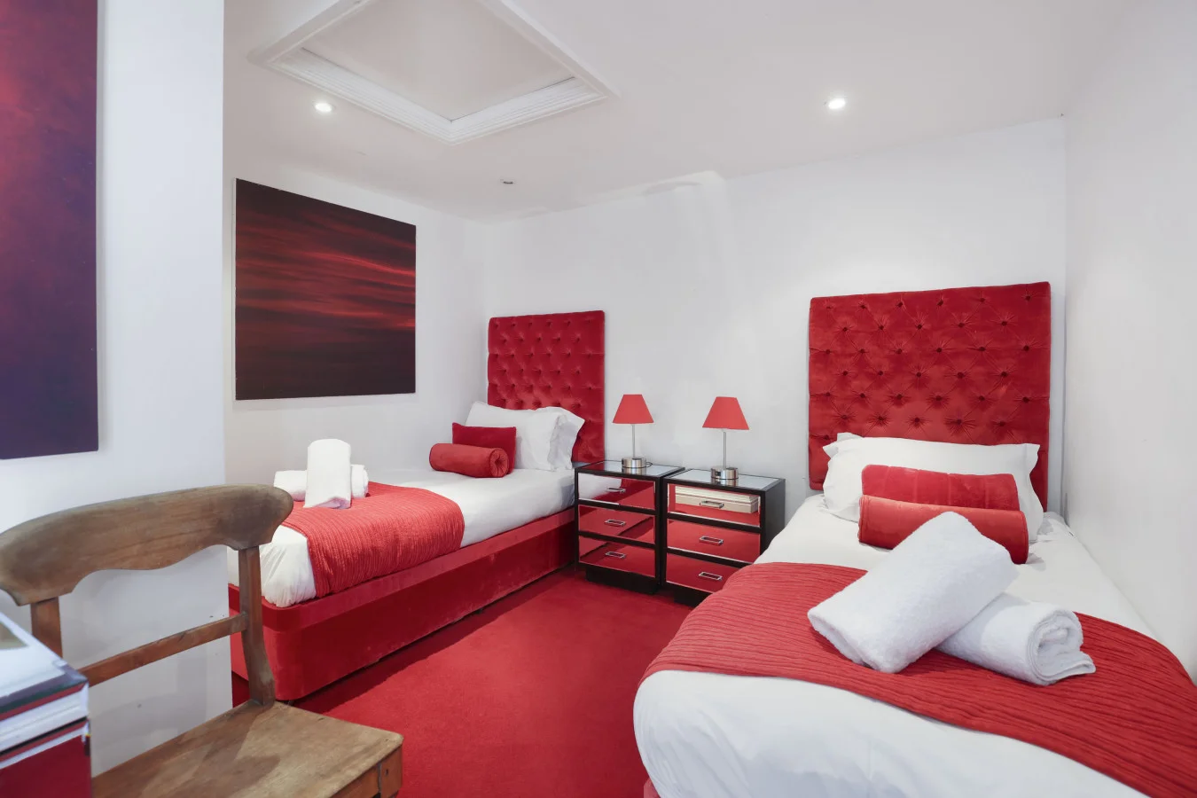 Twin bedroom with red upholstered headboards