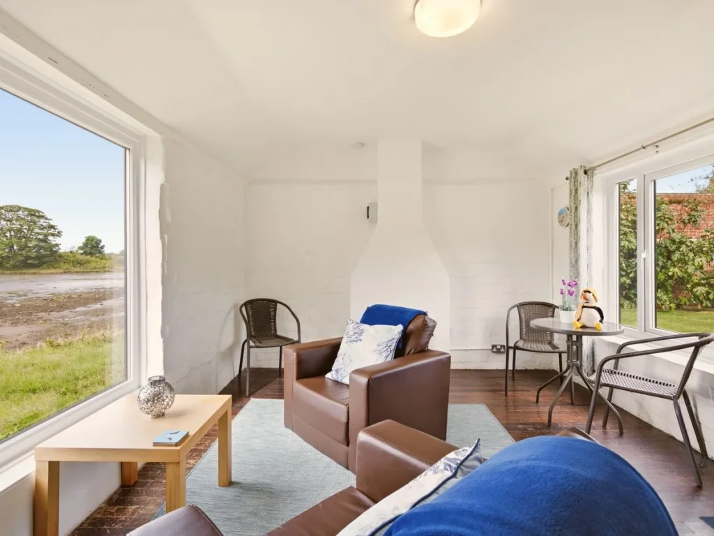 Jetty Cottage lounge with comfortable seating and waterside views
