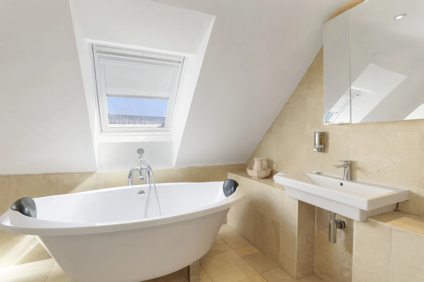 Family bathroom with freestanding bath and travertine tiles