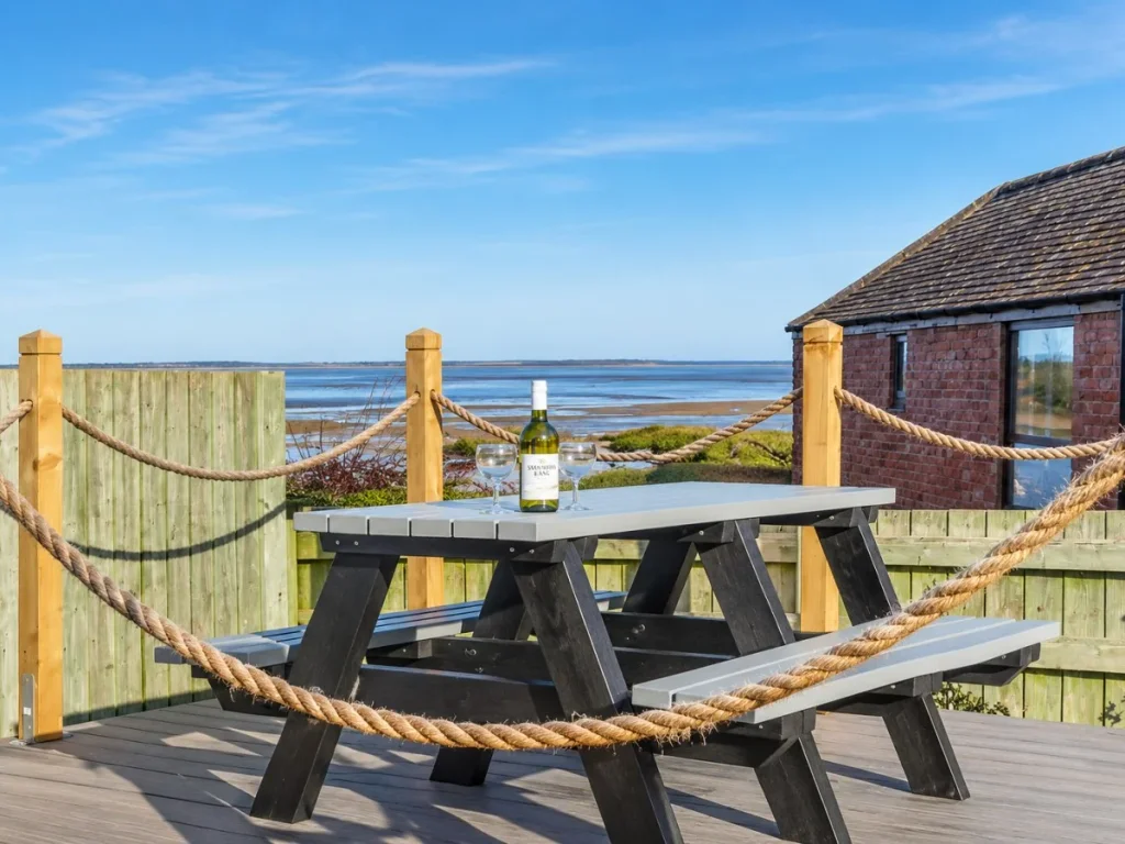 Decked seating area with picnic bench overlooking Budle Bay