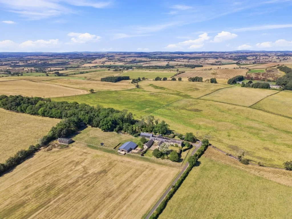 Wide countryside panorama with Roses Bower nestled among fields