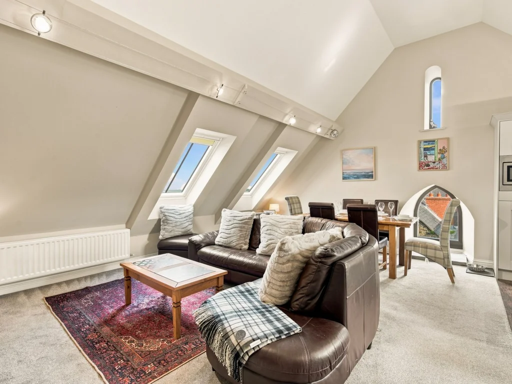 Open-plan living area with skylights, leather sofas and dining space.