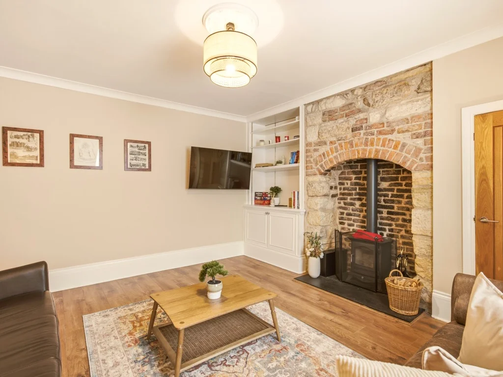 Characterful living room with feature fireplace, wood-burning stove and Smart TV.