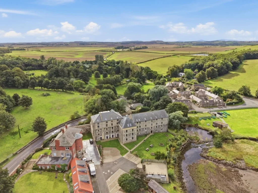 Aerial view of historic Waren Mill surrounded by open countryside
