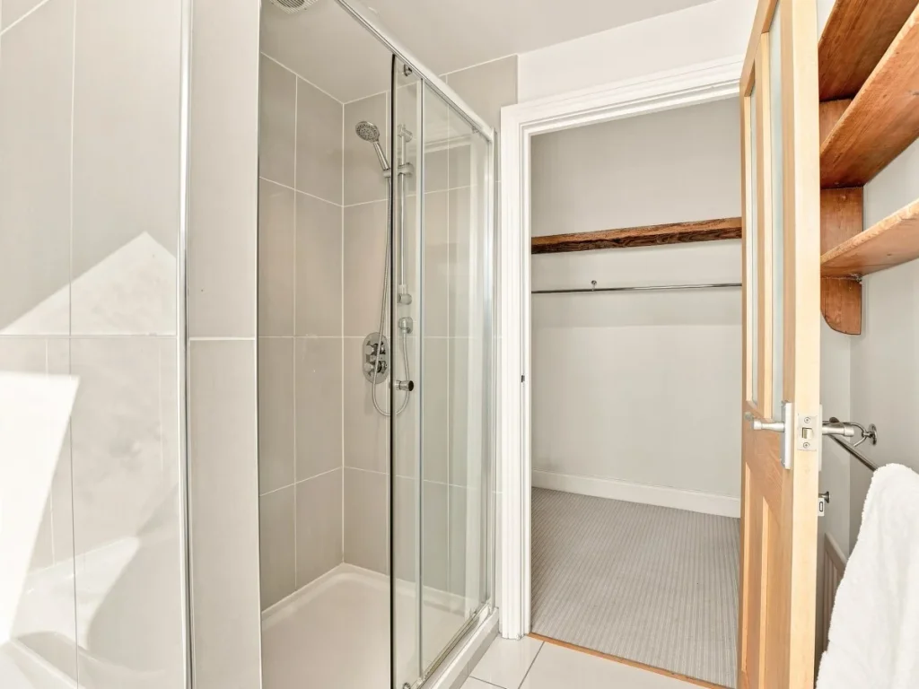 Glass shower enclosure beside a useful storage area