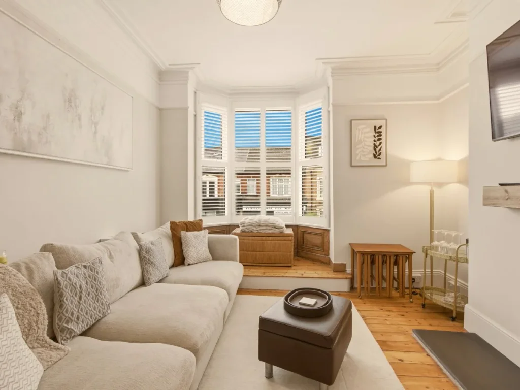 Bright bay window seating area with spacious sofa and side tables