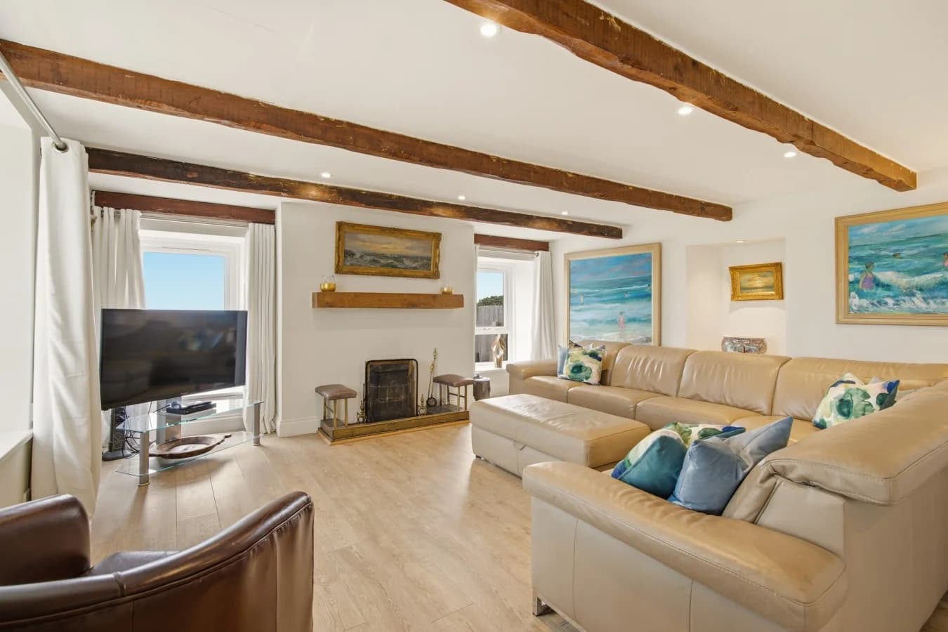Open-plan living area with exposed beams and oak flooring