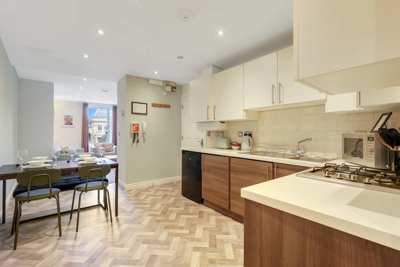 Modern kitchen and dining area with herringbone flooring and breakfast seating