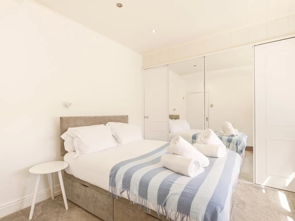 Double bedroom with mirrored wardrobes and soft neutral décor.
