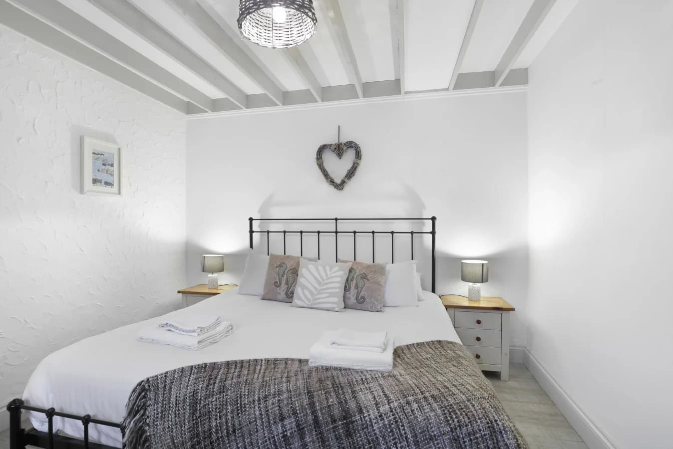 Double bedroom with wrought-iron bed and soft neutral tones