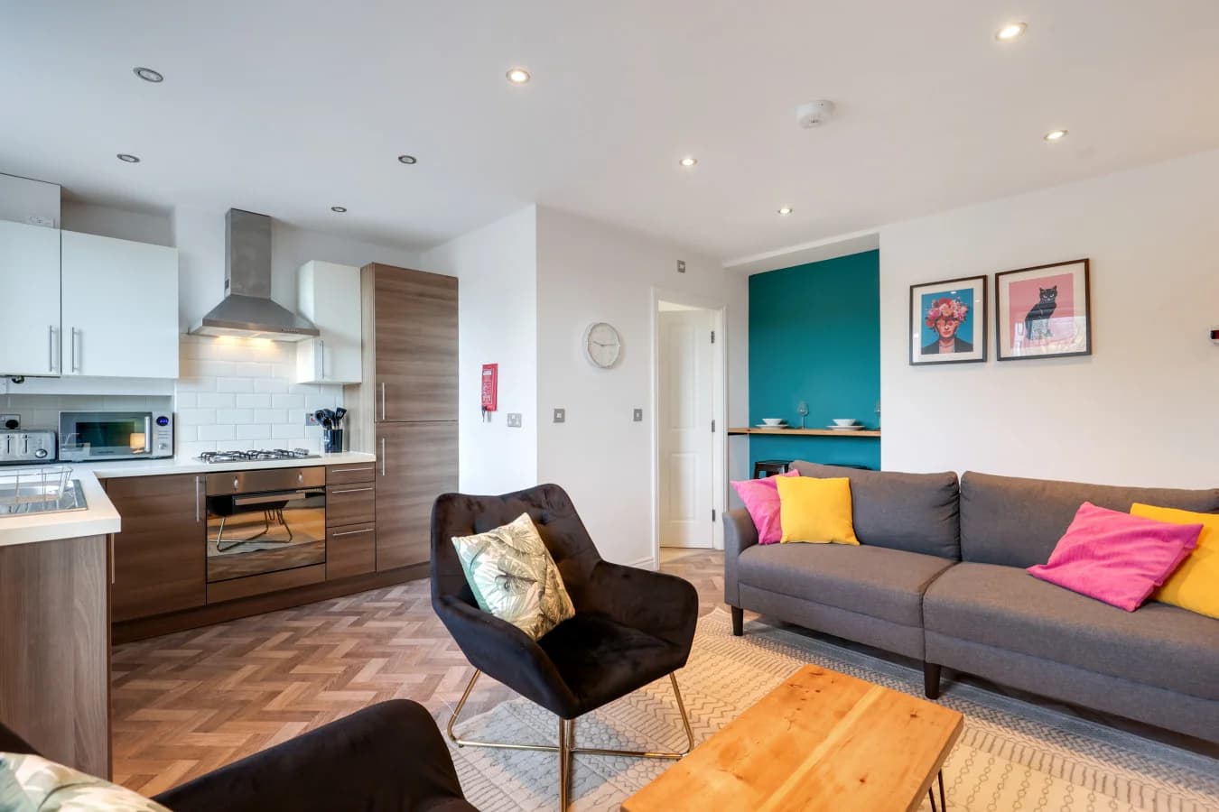 Bright lounge and kitchen area with parquet flooring and contemporary décor