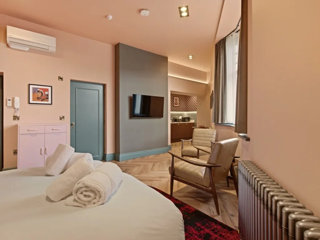 Double bed with fresh towels, seating area, Smart TV and air conditioning.