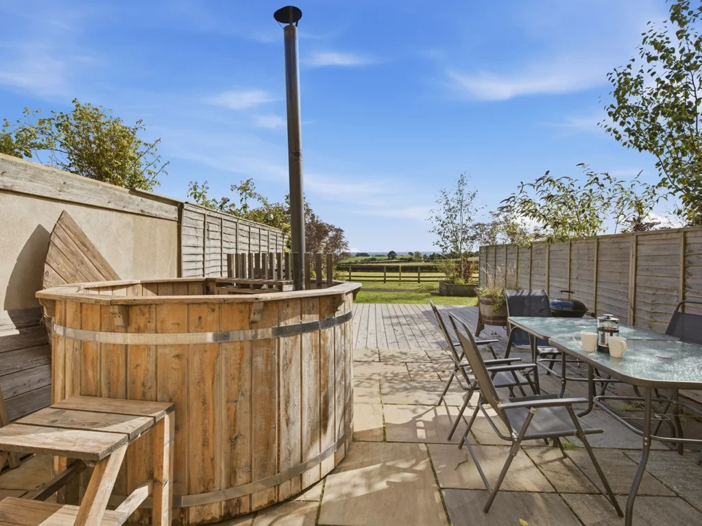 Wood-fired Scandi hot tub with outdoor dining on the patio