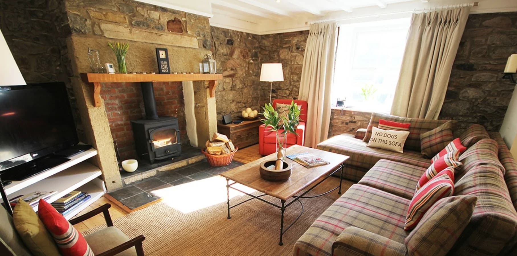 Cosy living room with log burner and traditional stone walls.