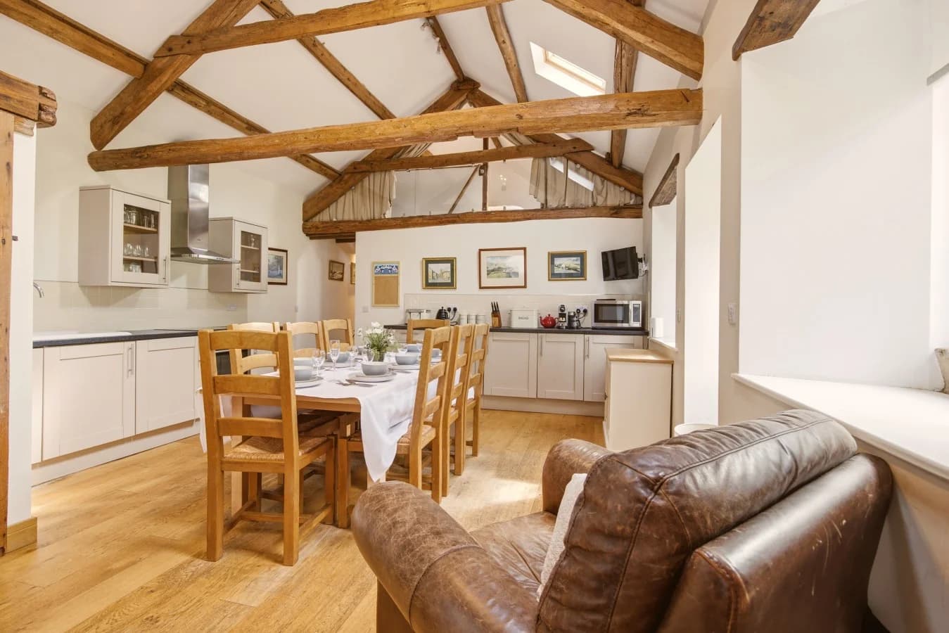Kitchen and dining area with exposed beams and vaulted ceiling