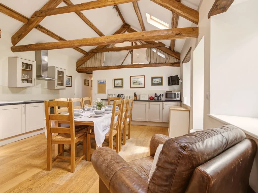 Kitchen and dining area with exposed beams and vaulted ceiling