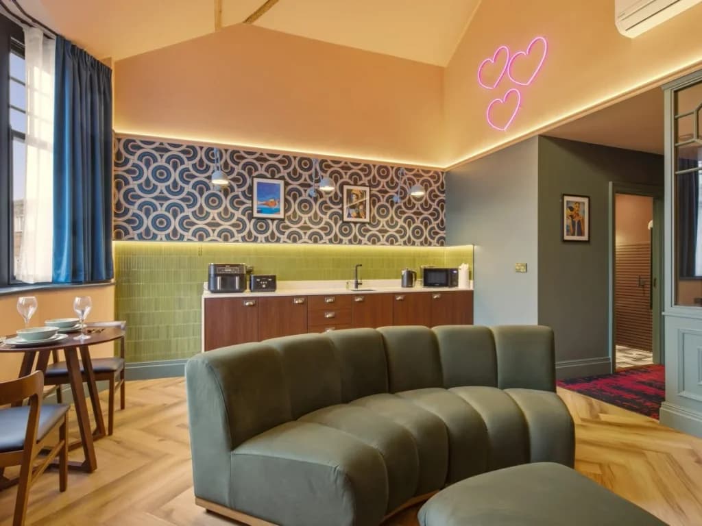 Kitchen and dining area with curved sofa and decorative wall features.