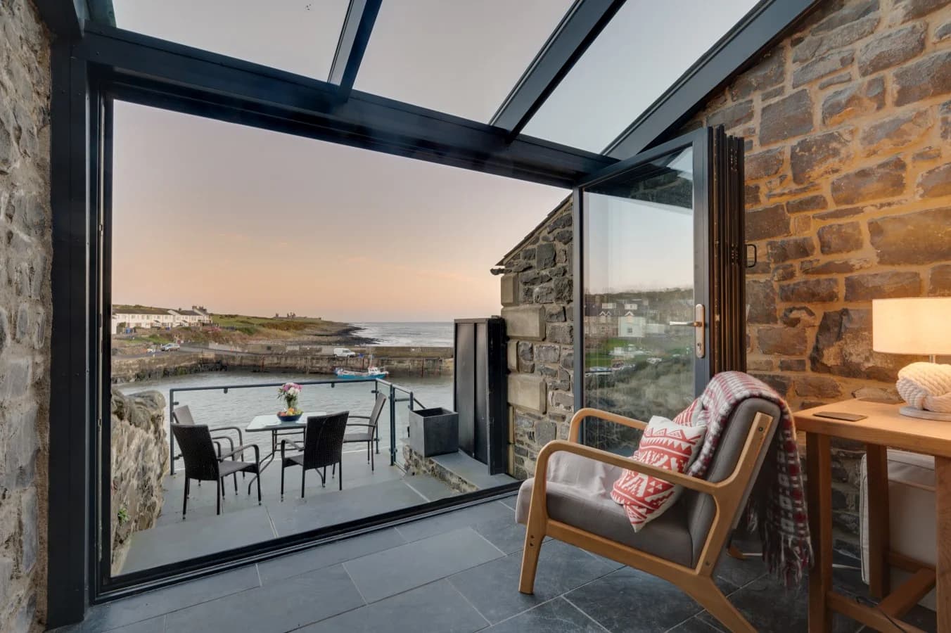 Stunning coastal outlook from the balcony, with outdoor seating overlooking Craster Harbour.