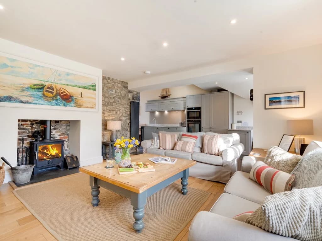 Welcoming living room with comfortable seating, exposed stonework and a cosy wood-burning stove.