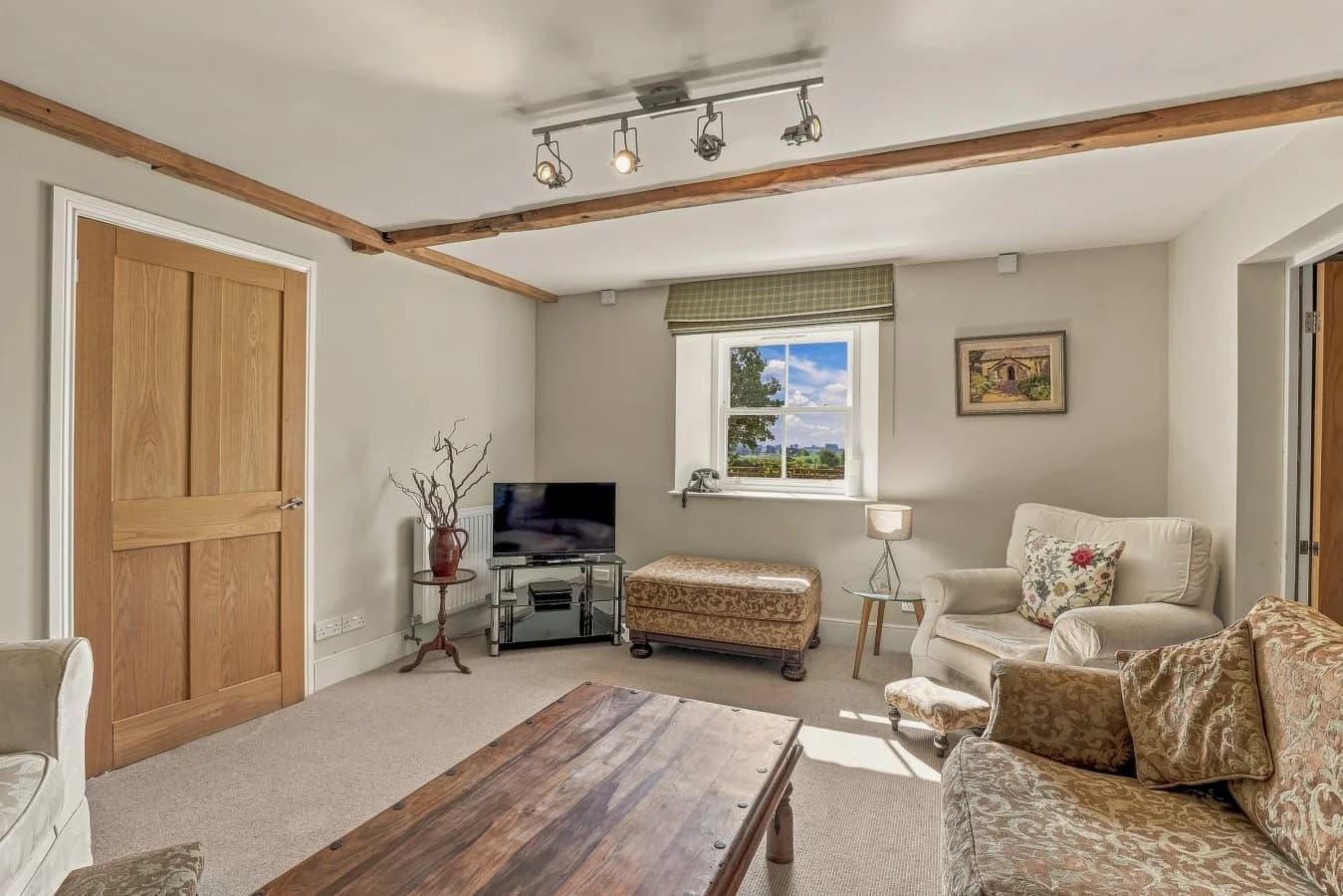 Comfortable living area with TV, armchairs and countryside view