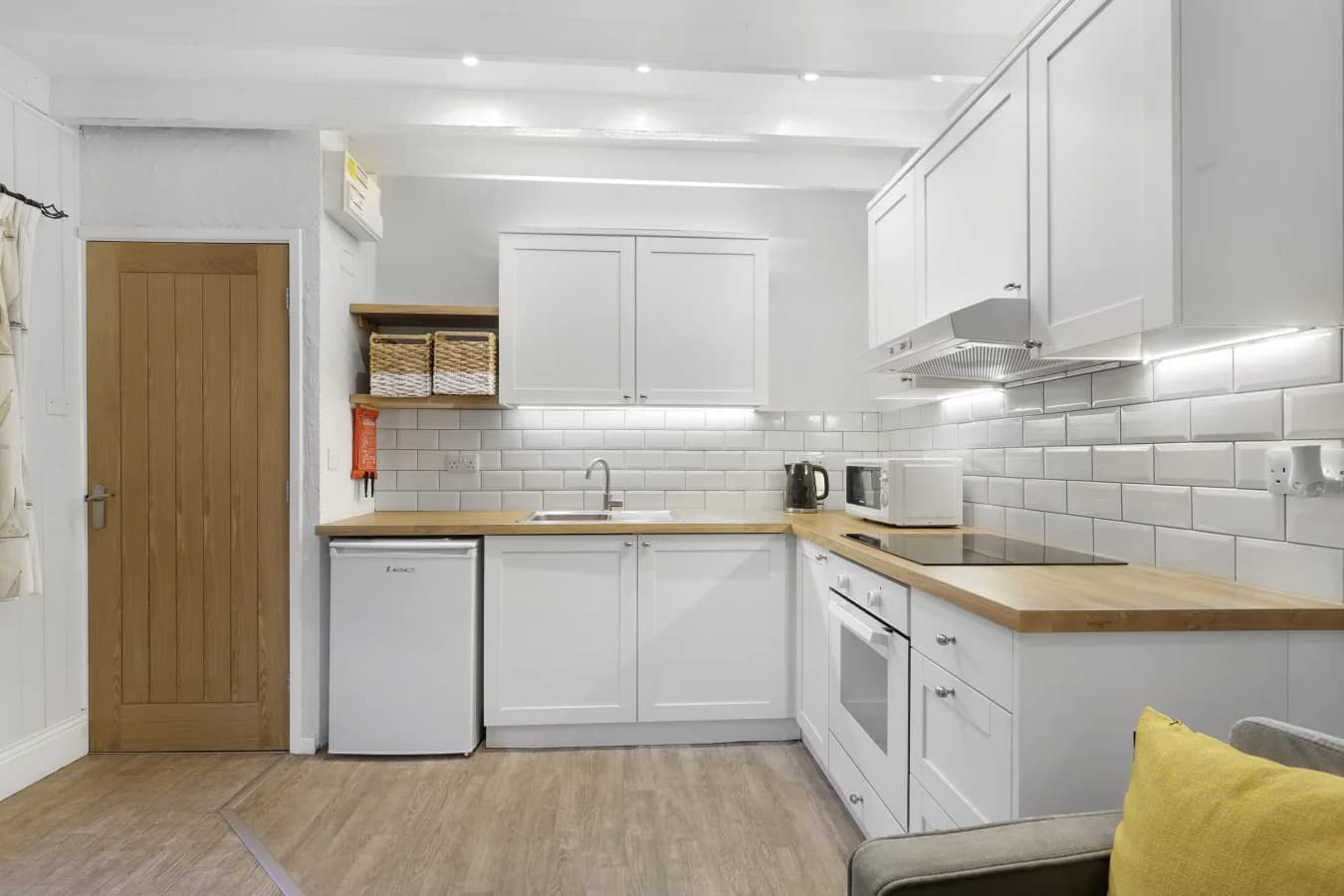 Well-equipped kitchen with shaker cabinetry and oak worktops