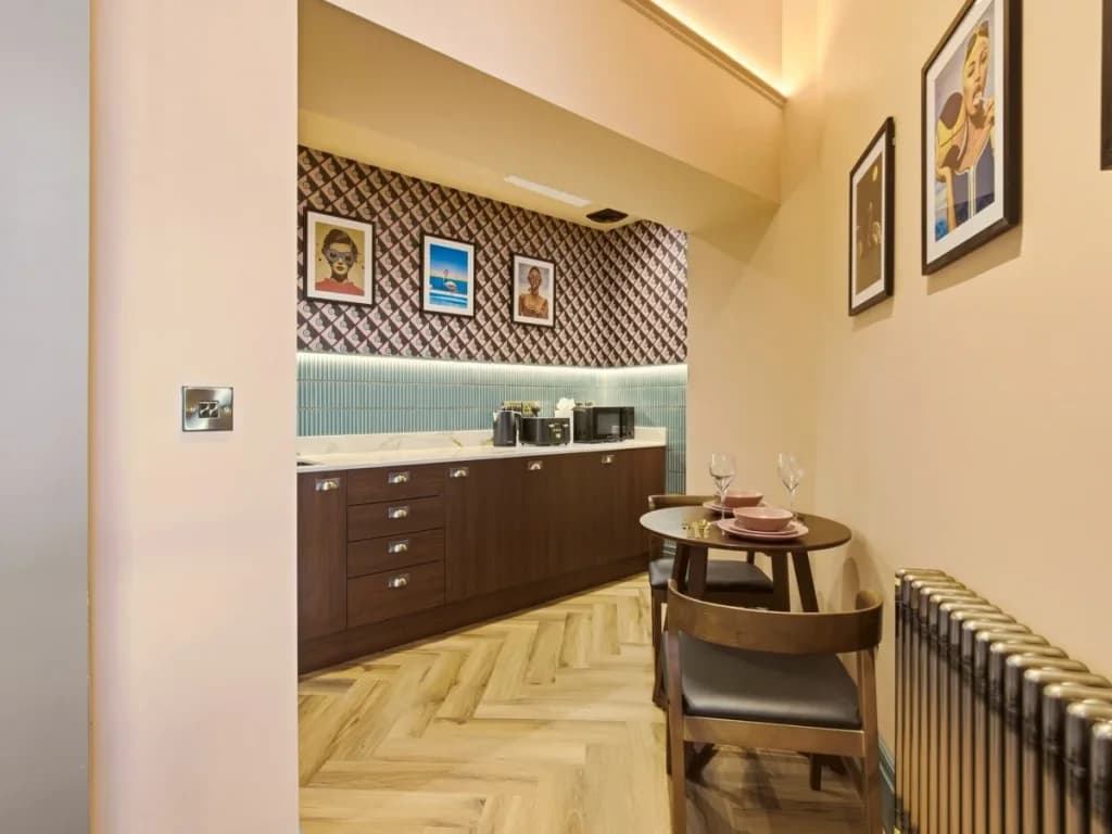 Kitchen and dining area with wood cabinetry and table set for two.