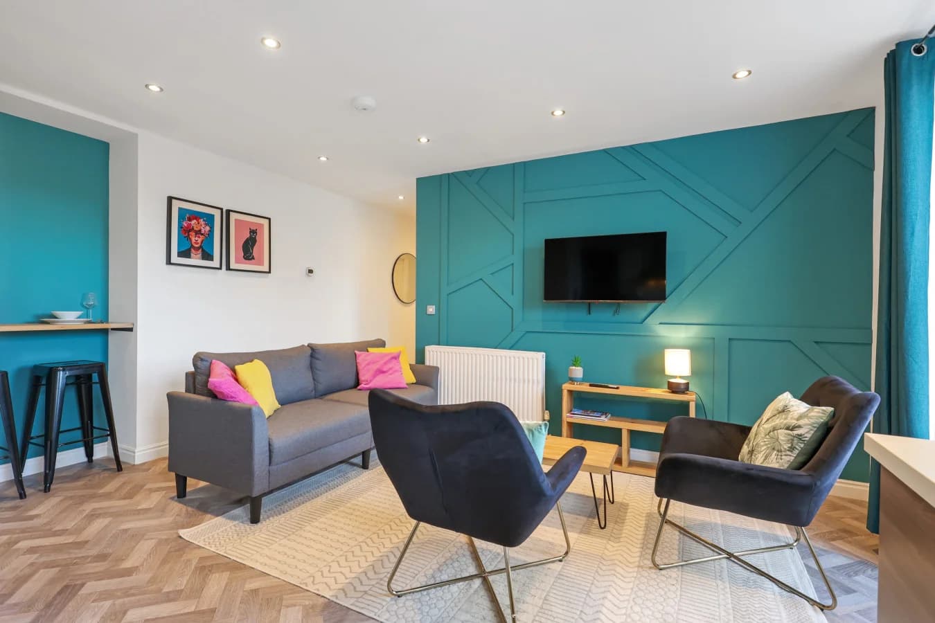 Comfortable seating area with bold teal panelling and modern furnishings