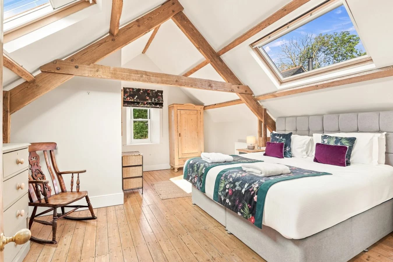 Bright bedroom with exposed beams, skylights and wooden floors