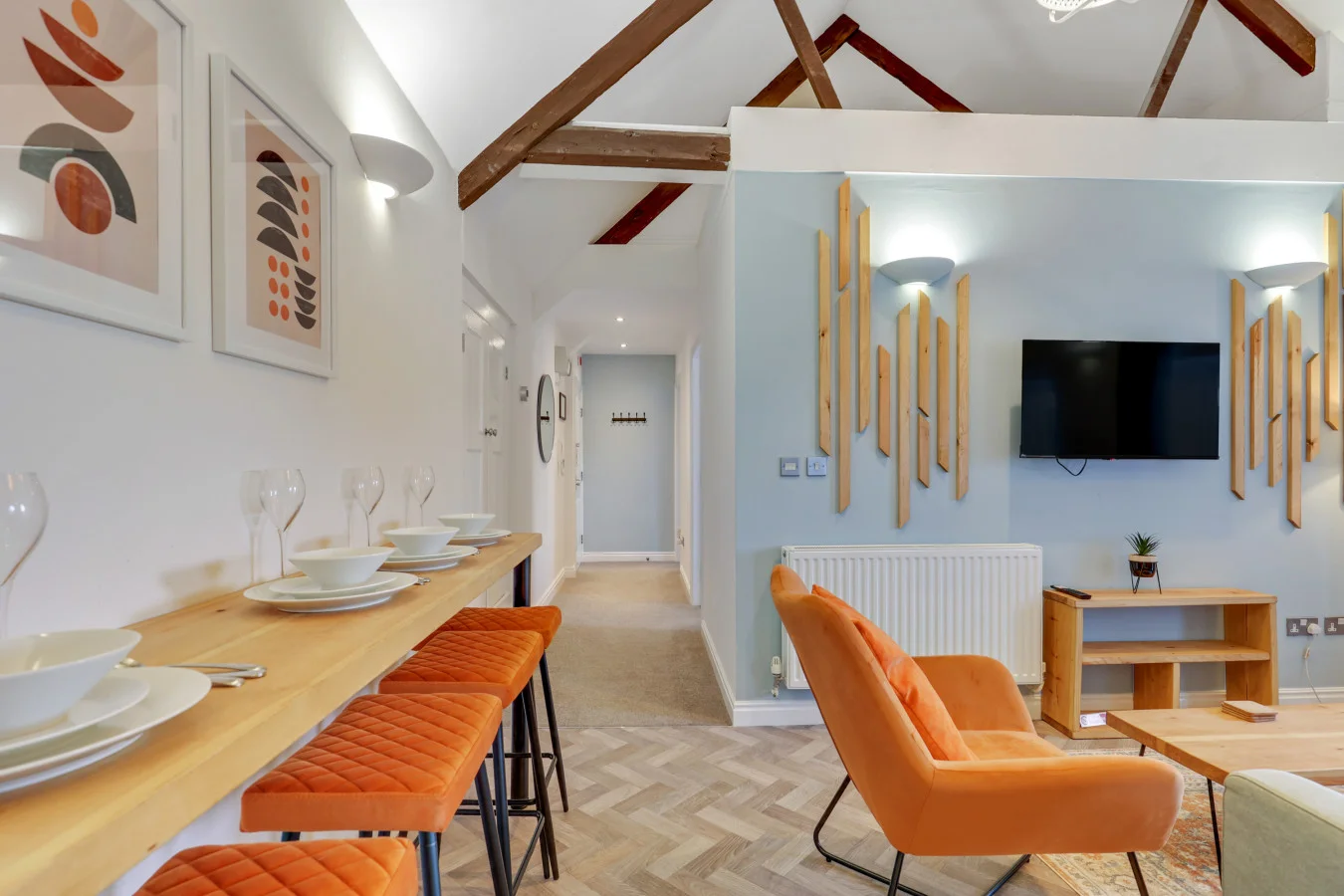 Breakfast bar dining area with burnt orange seating and herringbone flooring