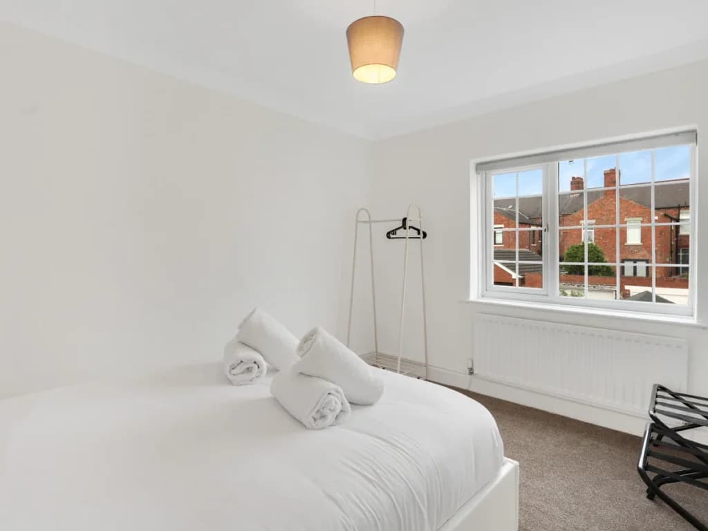 Bright double bedroom with hanging rail, luggage rack and large window