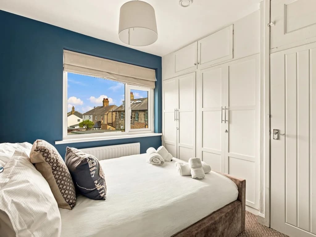 King bedroom with large fitted wardrobes and village view.
