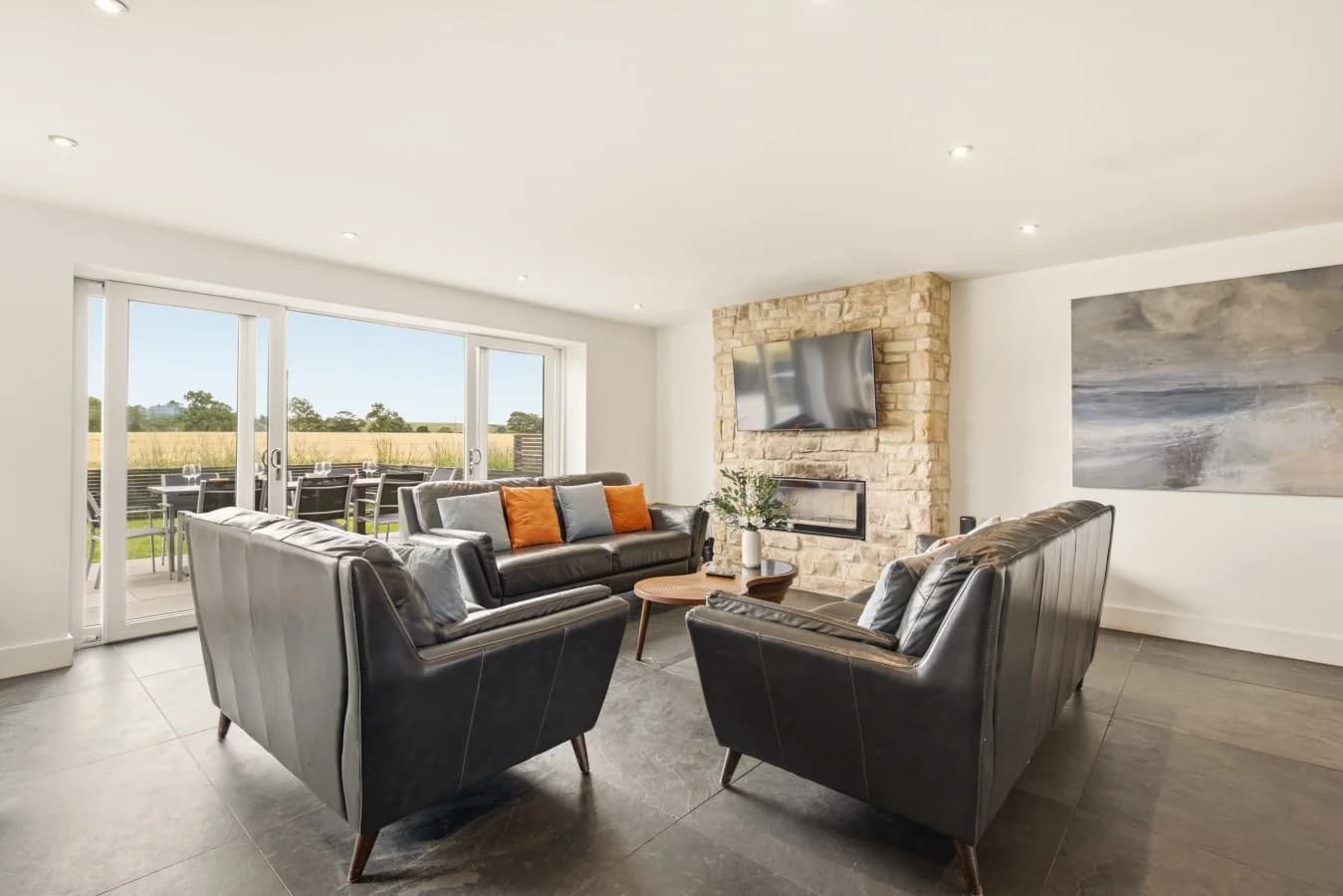 Open-plan lounge with countryside views and stone fireplace